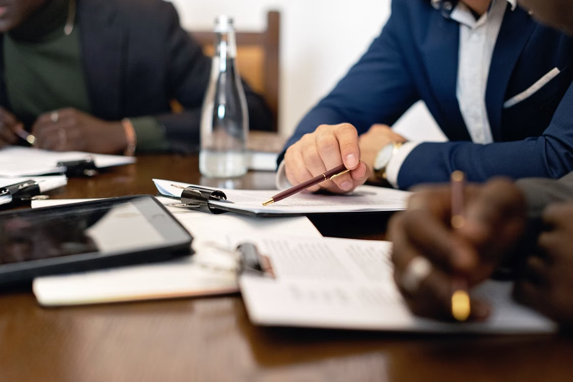 Équipe en réunion de travail autour de documents
